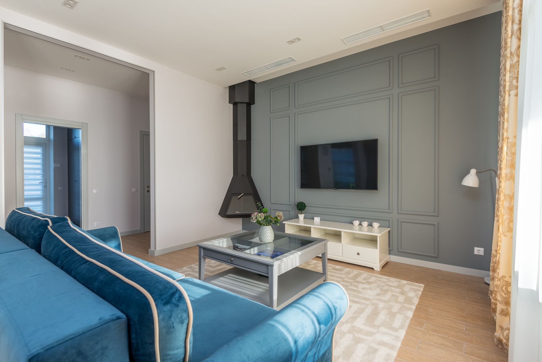 Renovated living room with panel accent wall and suspended fireplace