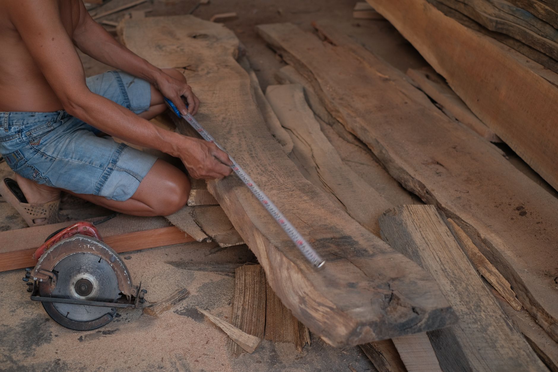 Carpenter measuring hardwood planks on site