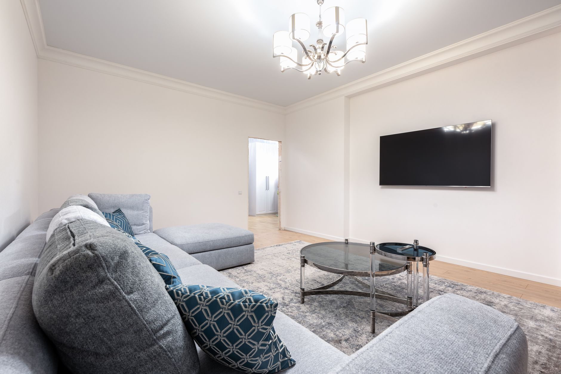Finished living room with gray sectional sofa and coved ceiling