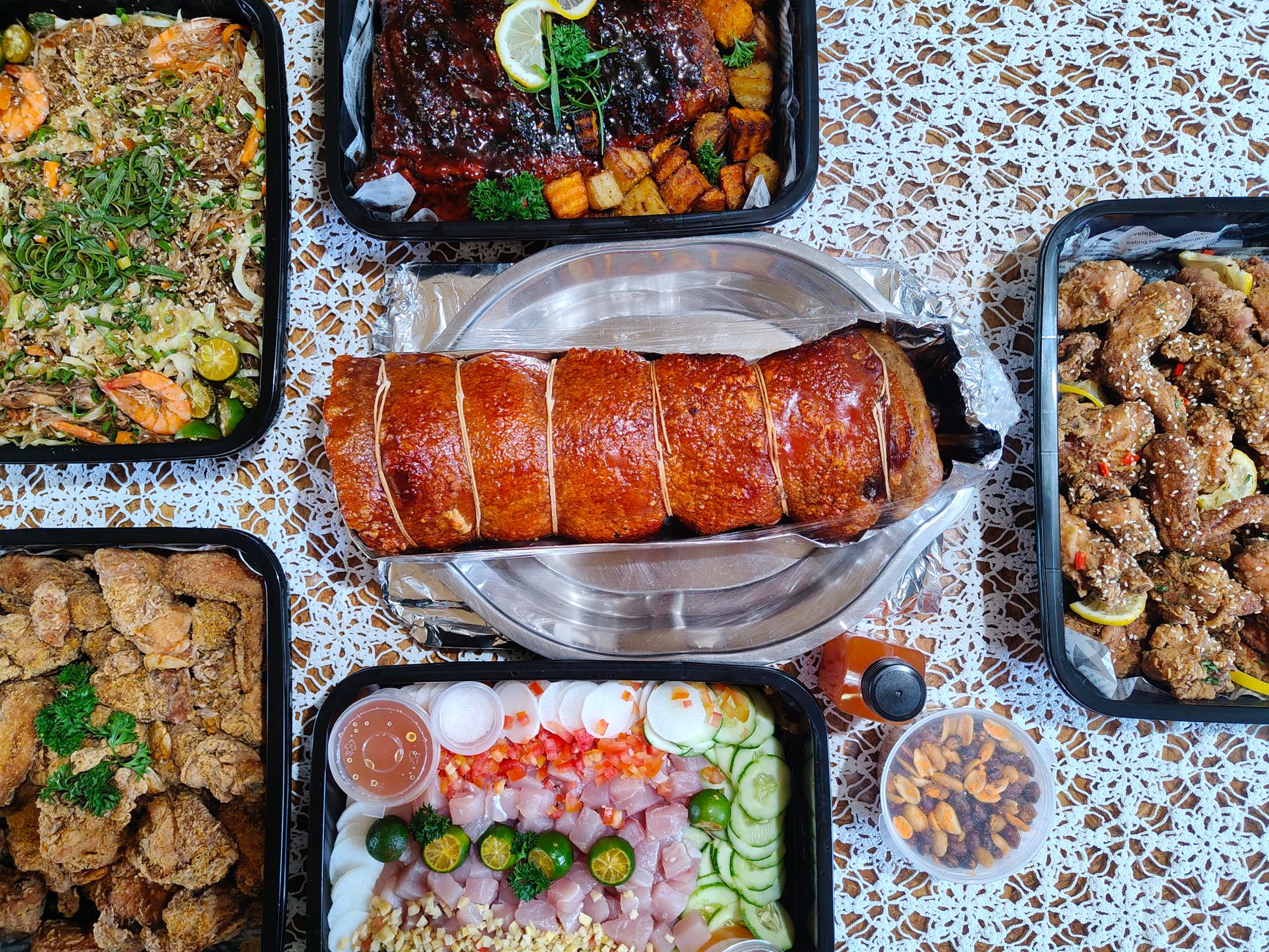 Filipino feast with lechon belly roll, pancit and kinilaw